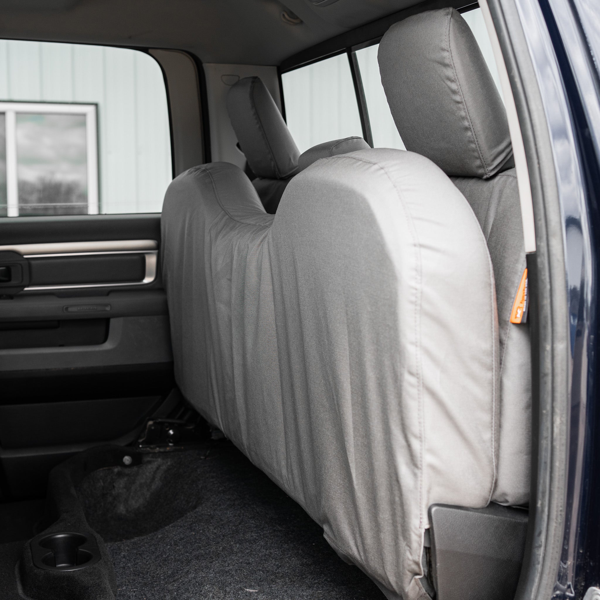Photo showing how this TigerTough seat cover for the RAM full bench seat covers the entire underside of the seat, which is great if you carry dogs or tools or anything in the back with that seat folded up.