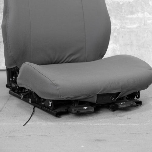 This is a close-up of the front seat bottom of a TigerTough heavy equipment seat cover. You can see how the seat cover works around the front seat controls.