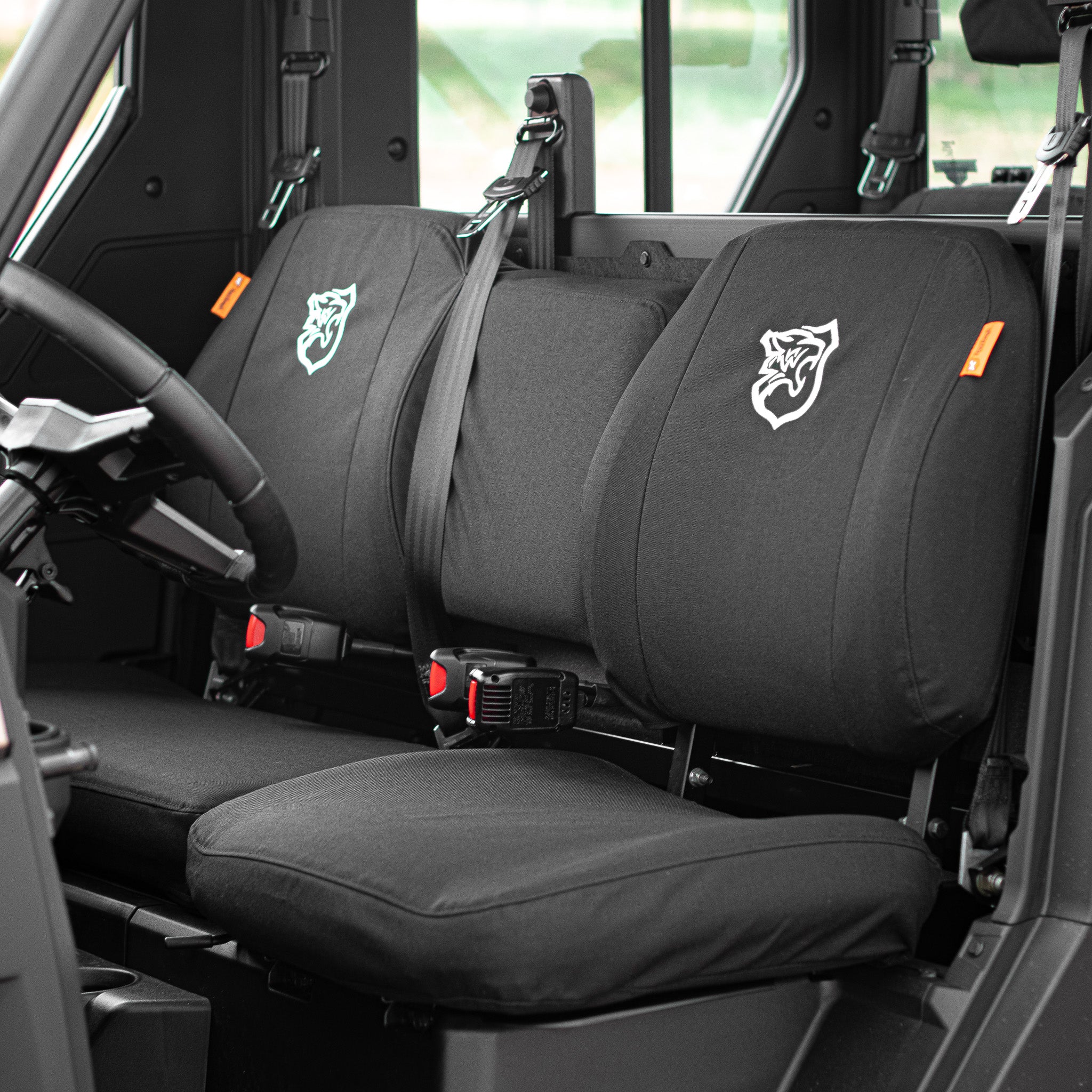 TigerTough Seat Covers in a Polaris Ranger side-by-side. TigerTough has seat covers for common side-by-sides, ATVs, and UTVs to protect their seats from the elements and the wear and tear of hard use. This set has the optional embroidery on the seat backs.